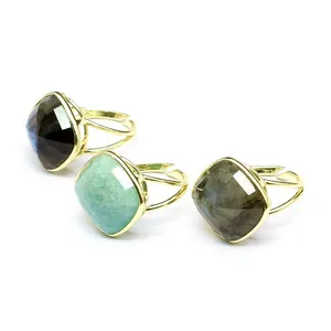Detalle de tres anillos de piedra natural con corte cojín y bandas doradas ajustables.