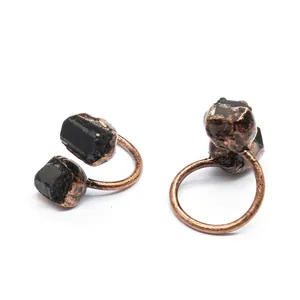 Macro shot of vintage copper-plated adjustable rings featuring raw black natural stones