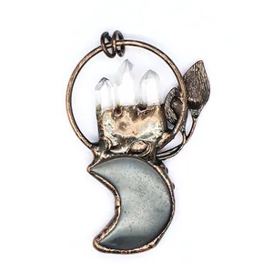 Close-up of vintage bronze moon pendant with clear crystal points and leaf detail.