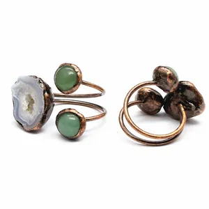 Detailed macro view of natural geode crystal and green stone on copper adjustable ring