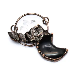 Detailed macro view of a vintage bronze moon pendant with clear crystal points.