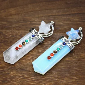 Detailed close-up of seven chakra crystal sword pendants on a textured wooden background