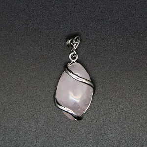 Marquise-cut rose quartz crystal pendant with silver heart bail on dark background