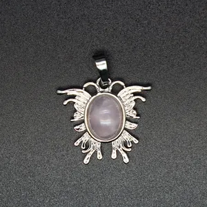 Nahaufnahme eines mottenförmigen Anhängers mit einem ovalen rosa Naturstein in Silber