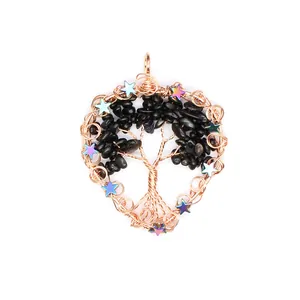 Close-up of handmade wire-wrapped tree of life pendant with black stones and stars.