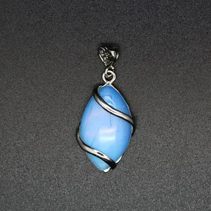 Detailed macro view of marquise-shaped blue stone pendant with silver heart bail