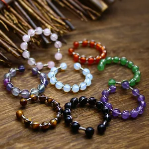 Set aus handgefertigten Ringen aus Naturstein in verschiedenen Farben auf Holzoberfläche