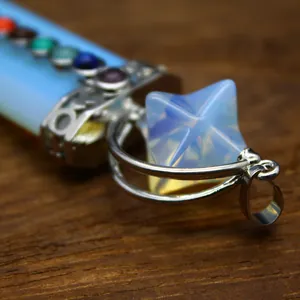Close-up detail of 7 Chakra crystal sword pendant featuring a Merkaba star stone design