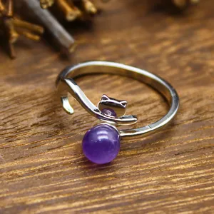 Close-up of fox-shaped silver open ring with round purple natural stone detail