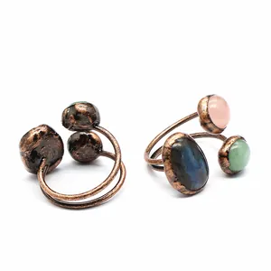 Close-up detail of two vintage copper rings featuring varied unshaped natural raw stones