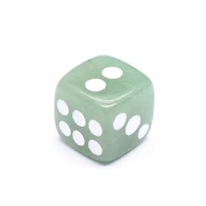 Vista detallada de un dado de piedra natural verde con puntos blancos para juegos