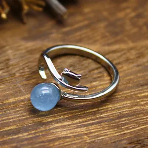 Close-up of silver-tone open ring featuring a fox silhouette and blue crystal bead.
