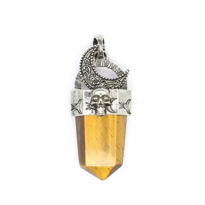 Détail d'un pendentif rétro avec lune, crâne et pointe de cristal en œil de tigre