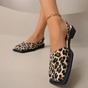 Primo piano di sandali bassi leopardati con punta quadrata e cavigliera oro.
