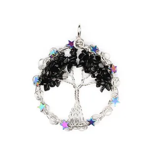 Detail shot of a silver-wired tree of life pendant with black chips and stars.