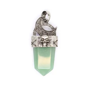 Vue détaillée d'un pendentif lune et crâne en argent avec pointe de cristal vert