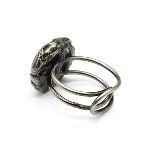 Dettaglio della tormalina nera grezza su un anello d'argento in stile vintage antico.
