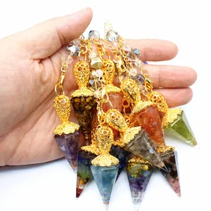 Detailed macro view of colorful natural stone resin hexagonal cone pendulum pendants in hand