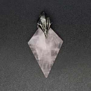 Detailed macro view of a natural rose quartz kite-shaped pendant with a trident metal cap