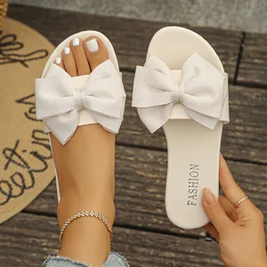Eleganti sandali piatti color crema caratterizzati da un grande fiocco strutturato
