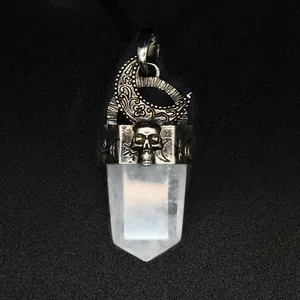 Détail de gravure de crâne et lune en argent vintage sur pendentif cristal blanc.