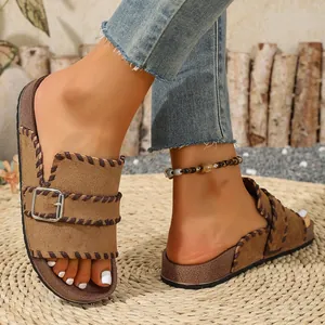 Close-up of retro suede platform sandals with whipstitch detail and metal buckle.