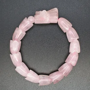 Detaillierte Nahaufnahme eines Armbands aus rosa Quarz mit geschnitztem Drachenkopf
