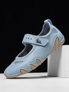 Light blue sporty Mary Jane shoe with a Velcro strap and ram logo on a black background