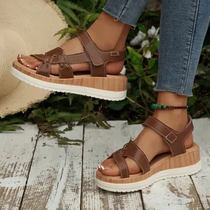 Side profile detail of brown cross-strap wedge sandals with wood-grain platform sole