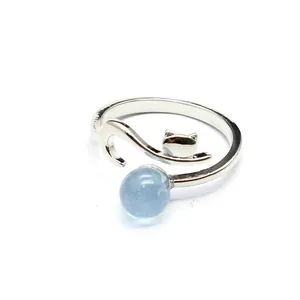 Close-up of a silver fox-shaped open ring featuring a translucent blue aquamarine stone.