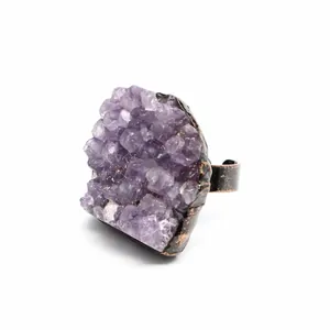 Primo piano dettagliato di un anello in drusa di ametista grezza con finitura in metallo