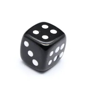 Primer plano de un dado de piedra natural negra pulida para juegos de mesa creativos