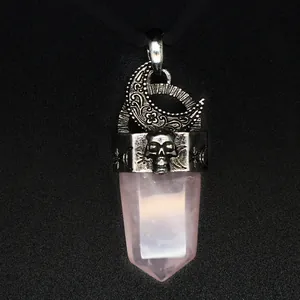 Gros plan d'un motif lune et crâne rétro sur un pendentif en pointe de quartz rose