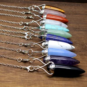 Row of varied natural stone bullet pendants with silver chains on wood