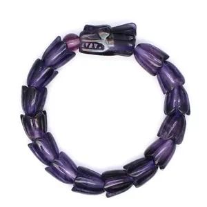 Detaillierte Nahaufnahme des kunstvoll geschnitzten lila Drachenschuppen-Armbands