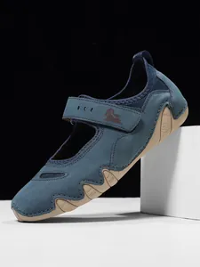 Close-up detail of blue Mary Jane sneakers with velcro strap and wavy rubber sole