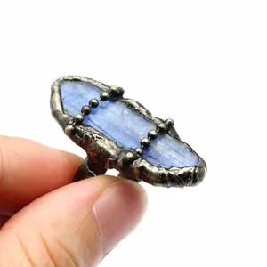Primo piano di un anello vintage con cianite blu grezza e montatura nera testurizzata
