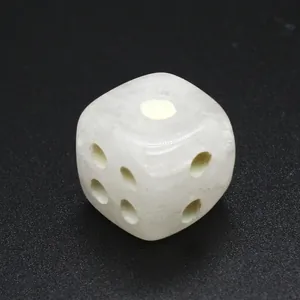 Primer plano de un dado de piedra de cristal natural blanco con puntos tallados