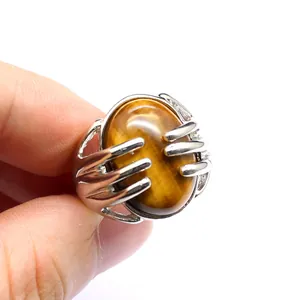 Close-up view of a natural tiger eye stone ring with unique silver hand claw setting