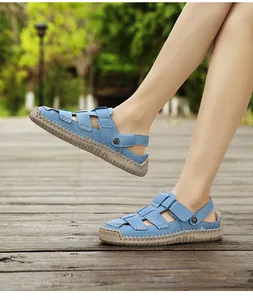 Close-up of stylish blue leather sandals for women on a wooden deck