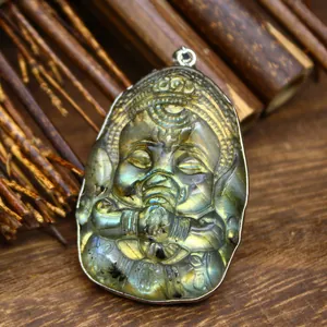 Macro detail of hand-carved natural labradorite baby elephant pendant with iridescent glow