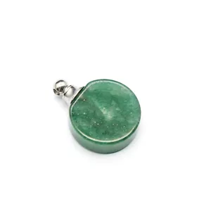 Gros plan d'un pendentif flacon d'huile essentielle en pierre verte avec bouchon argenté.