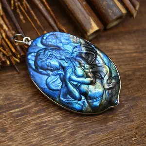Detail view of a hand-carved mermaid pendant made of natural labradorite with stunning blue flash.