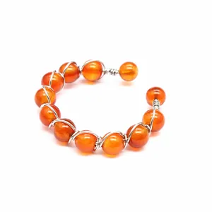 Detailansicht eines handgefertigten verstellbaren Rings mit orangen Natursteinperlen