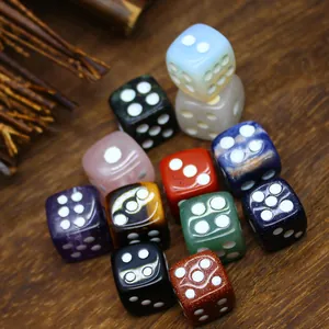 Primer plano de dados de piedra natural multicolor con puntos grabados en blanco