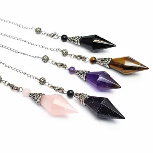 Detail shot of multi-colored hexagonal crystal pendulums with ornate silver caps and chains.