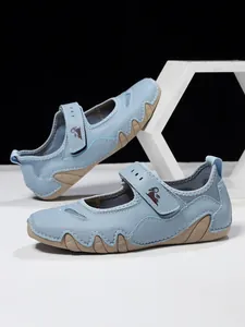 Detail of light blue Mary Jane casual sandals with adjustable velcro strap for summer.