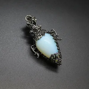 Detailed view of antique silver teardrop pendant featuring white opalite stone in gothic filigree