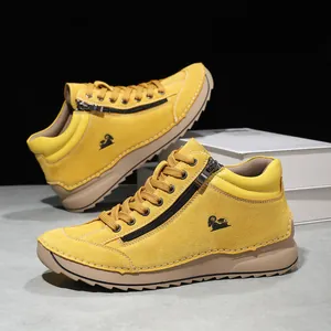 Detail view of yellow hand-stitched casual high-top shoes with side zipper and soft sole.