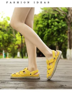 Detailed side view of trendy yellow leather closed-toe sandals worn on a wooden path